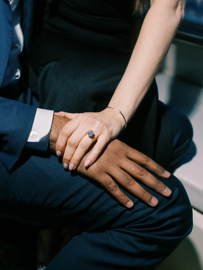 Gros plan d'une bague de fiançailles en diamant lors d'une séance photo de couple avec un photographe.