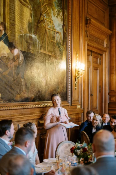 Bridesmaid delivering an emotional speech captured by a French wedding photographer in a chateau.