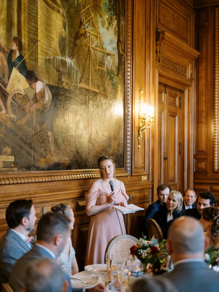 Bridesmaid delivering an emotional speech captured by a French wedding photographer wedding photographer in a chateau.