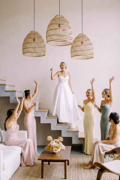 Bride and bridesmaids toast with champagne captured by a French wedding photographer in a luxury villa.