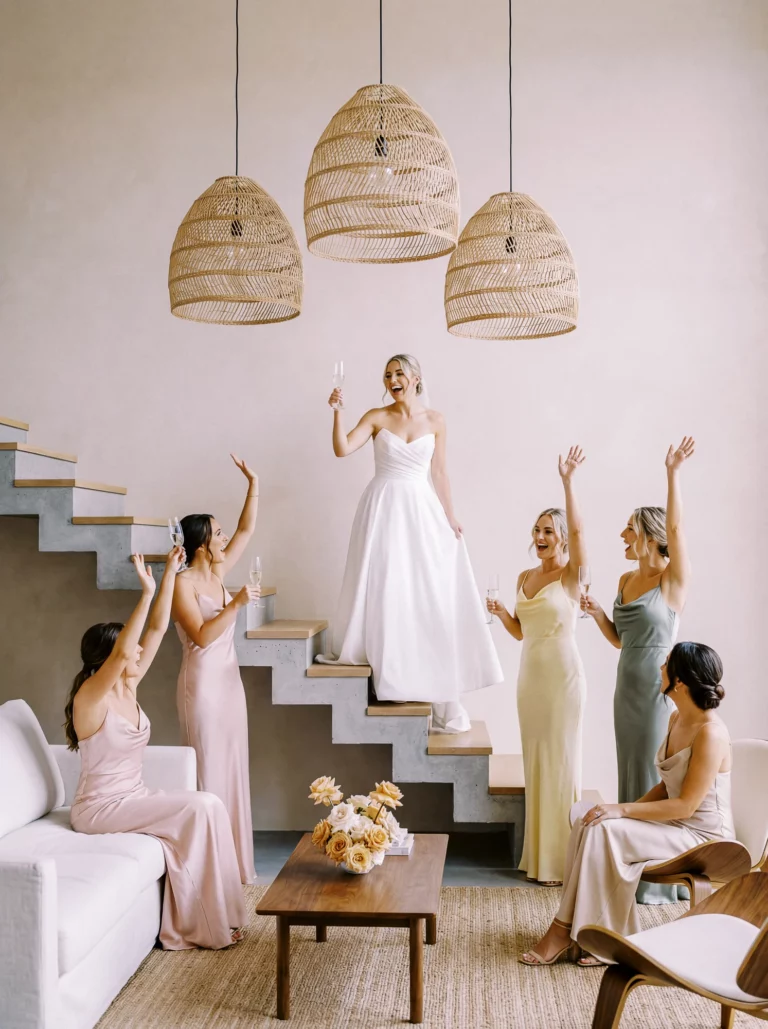 Bride and bridesmaids toast with champagne captured by a French wedding photographer in a luxury villa.