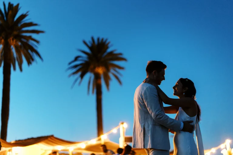 Portrait intimiste de couple sous les palmiers au crépuscule par un photographe de mariage.