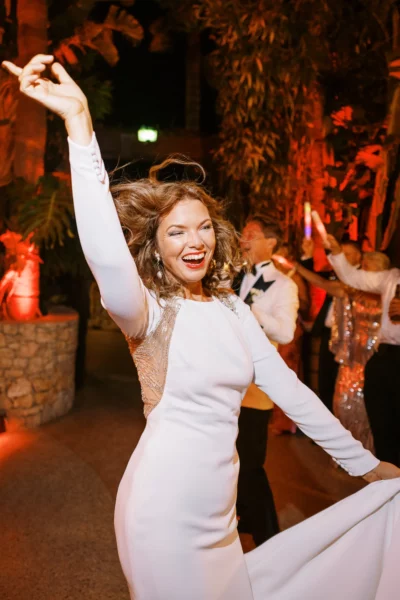 Joyful bride dancing at a luxury reception captured by a French wedding photographer.