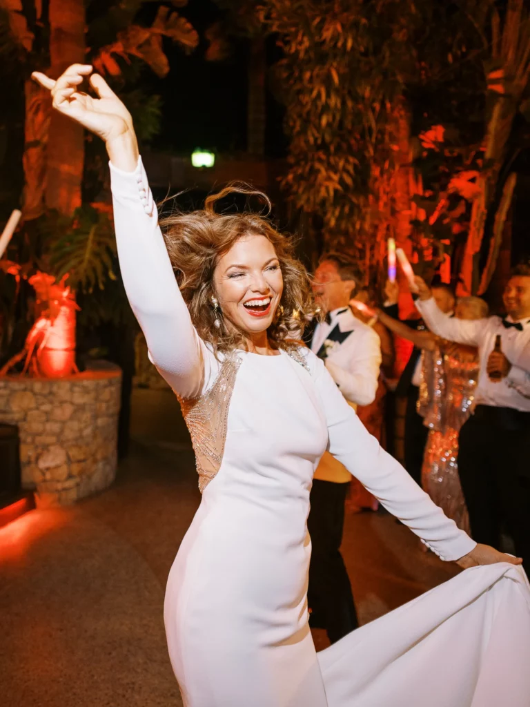 Joyful bride dancing at a luxury reception captured by a French wedding photographer.