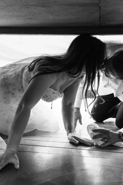 Bride and groom hiding under a table, captured by a french wedding photographer.