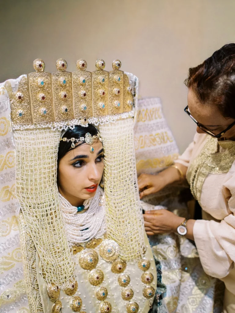 A Moroccan bride in traditional gold regalia during preparation by a French wedding photographer.