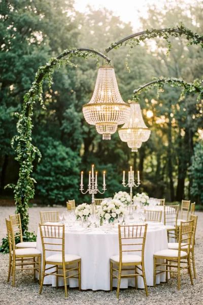 Elegant outdoor reception table with crystal chandeliers by a French wedding photographer.