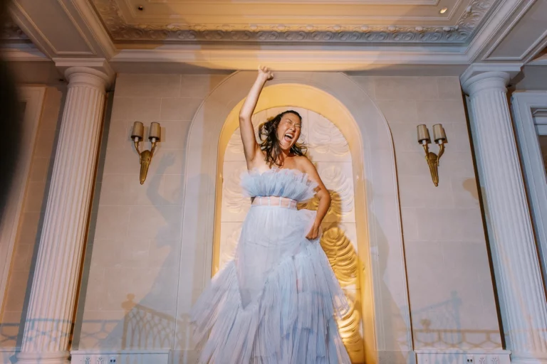 Bride in blue tulle dress dancing at a reception by a French wedding photographer wedding photographer.