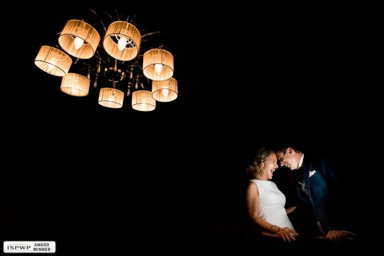 6-awards-wedding-photographer-joyful-couple-laughter-chandelier