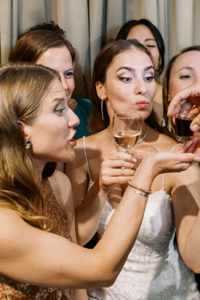 Bride and bridesmaids sharing a celebratory toast captured by a French wedding photographer.