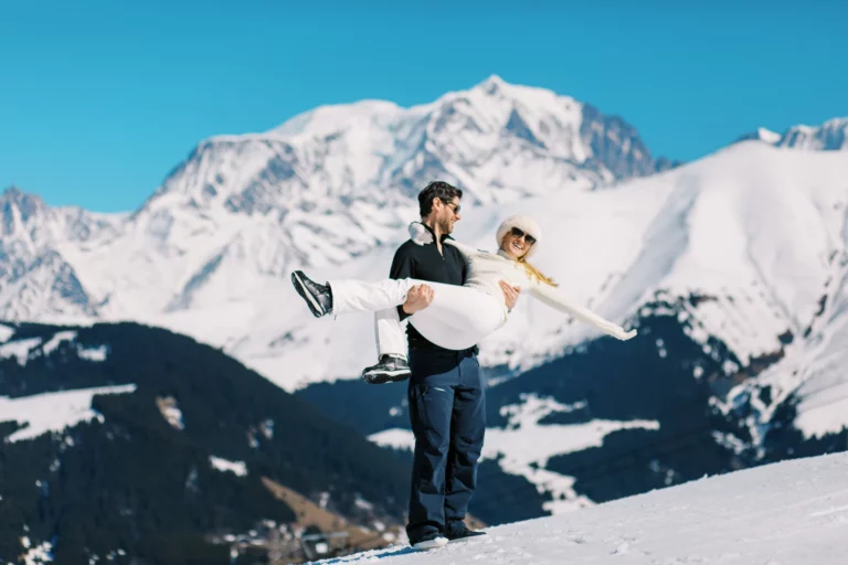 Homme portant sa fiancée sur les sommets enneigés, photo de couple wedding photographer.