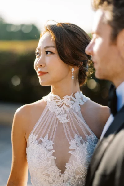 A bride in a lace gown captured by a French wedding photographer during golden hour.