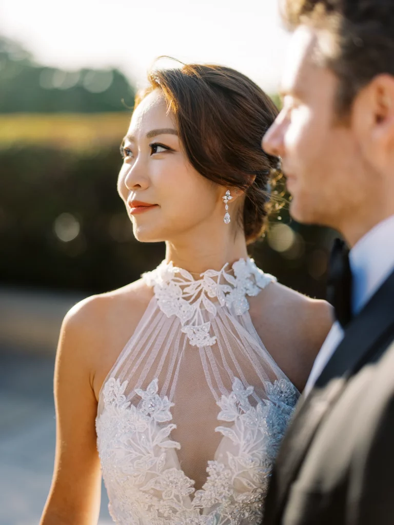 A bride in a lace gown captured by a French wedding photographer during golden hour.