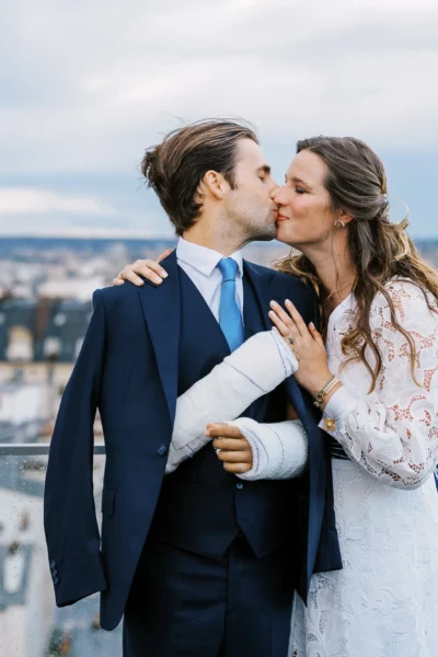 Bride and groom kissing on a Paris rooftop terrace by a European wedding photographer.