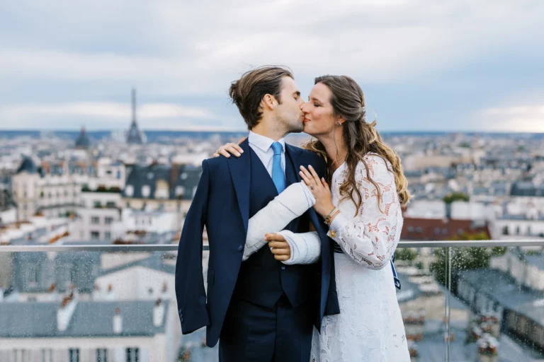 Bride and groom kissing on a Paris rooftop terrace by a European wedding photographer.