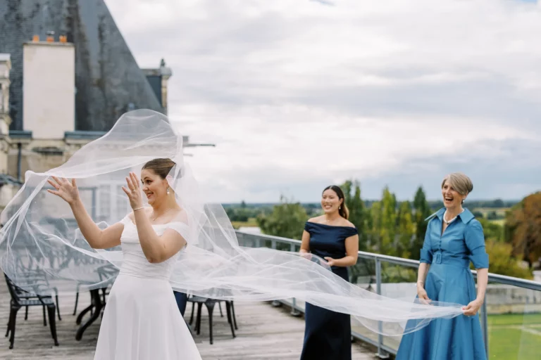 Bride with flowing veil on a chateau terrace by a european wedding photographer.