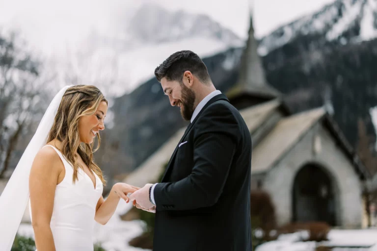 Un photographe de mariage capture un échange d'alliances intime à la Chapelle des Praz à Chamonix.