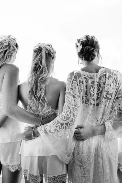 Bridesmaids in lace robes on a balcony by a french wedding photographer.