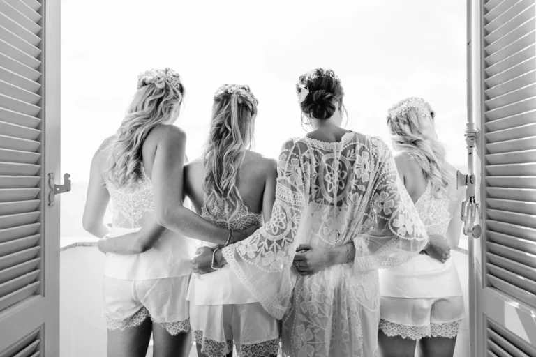 Bridesmaids in lace robes on a balcony by a french wedding photographer.