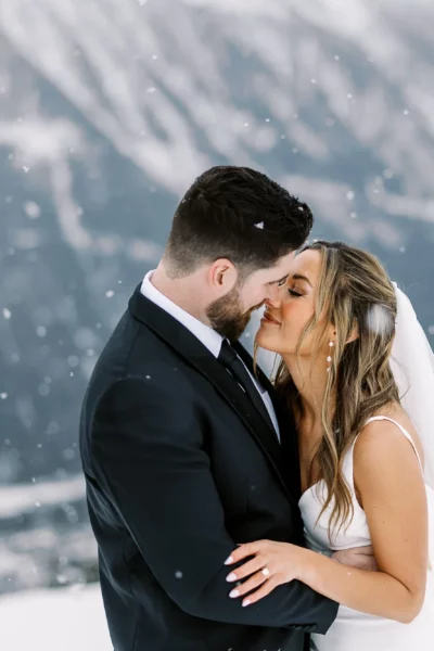 Bride and groom embrace in the snowy Alps captured by a french wedding photographer.
