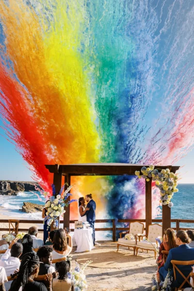 Vibrant rainbow smoke ceremony captured by a french wedding photographer at a luxury seaside wedding.