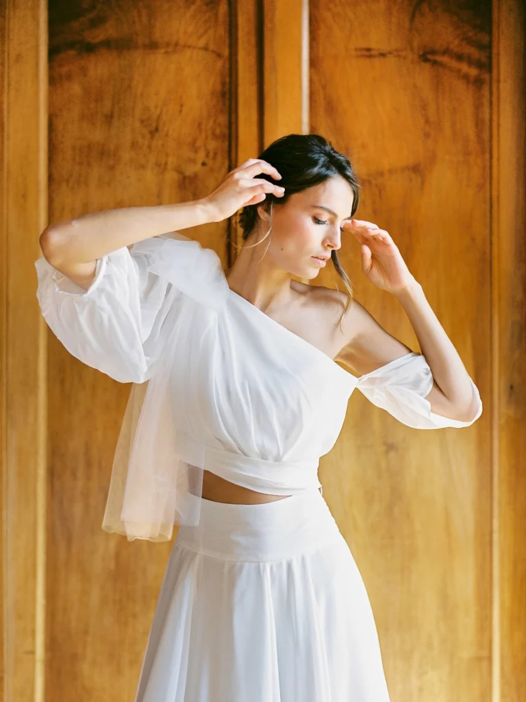 Bride in modern two-piece gown captured by a French wedding photographer in a chateau.