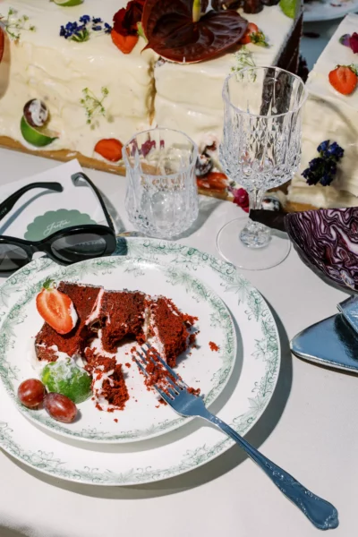 Luxury reception details by a French wedding photographer featuring red velvet cake and vintage crystal.