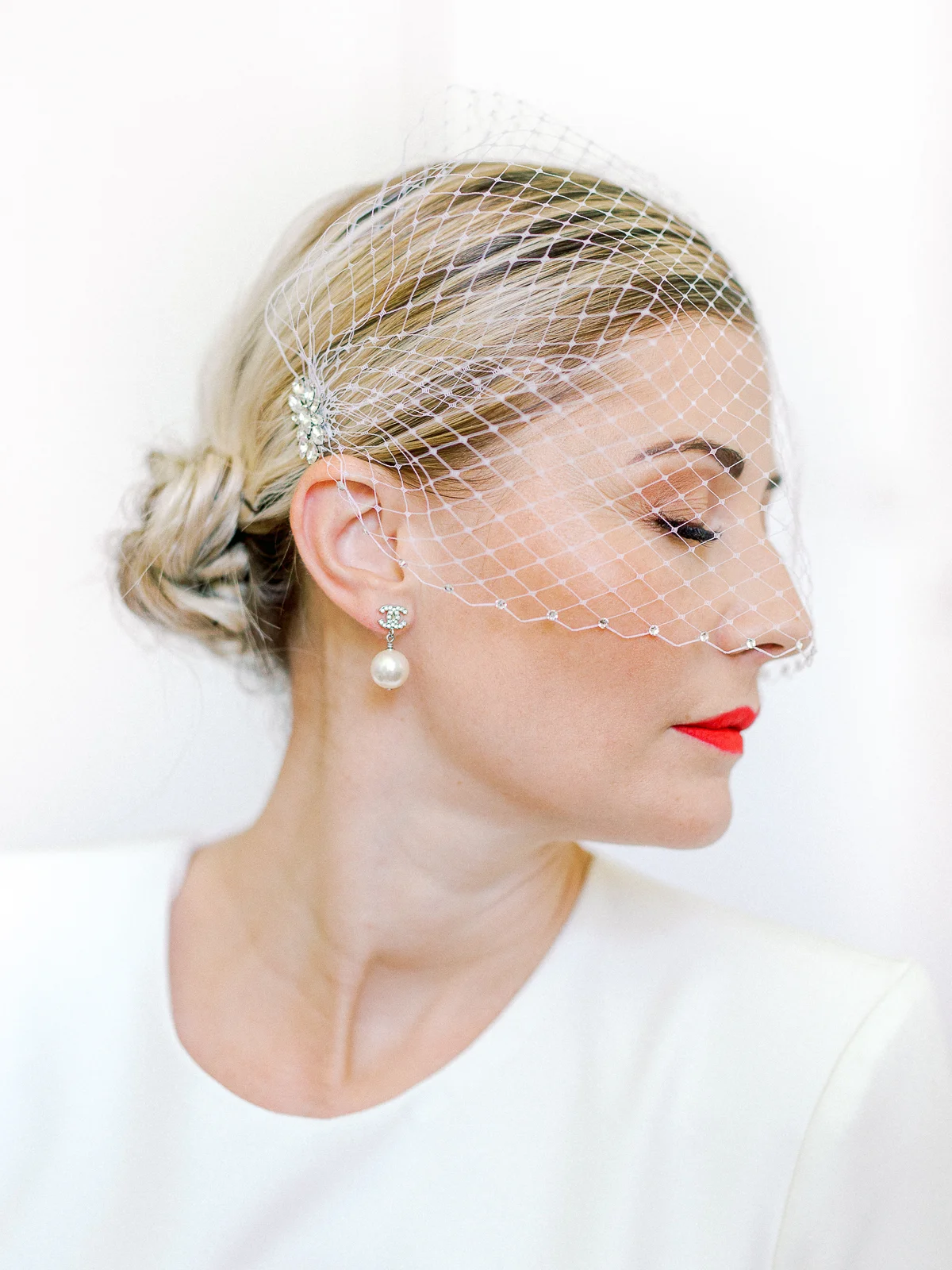 Portrait de mariée élégant avec voilette réalisé par un photographe mariage France en studio.
