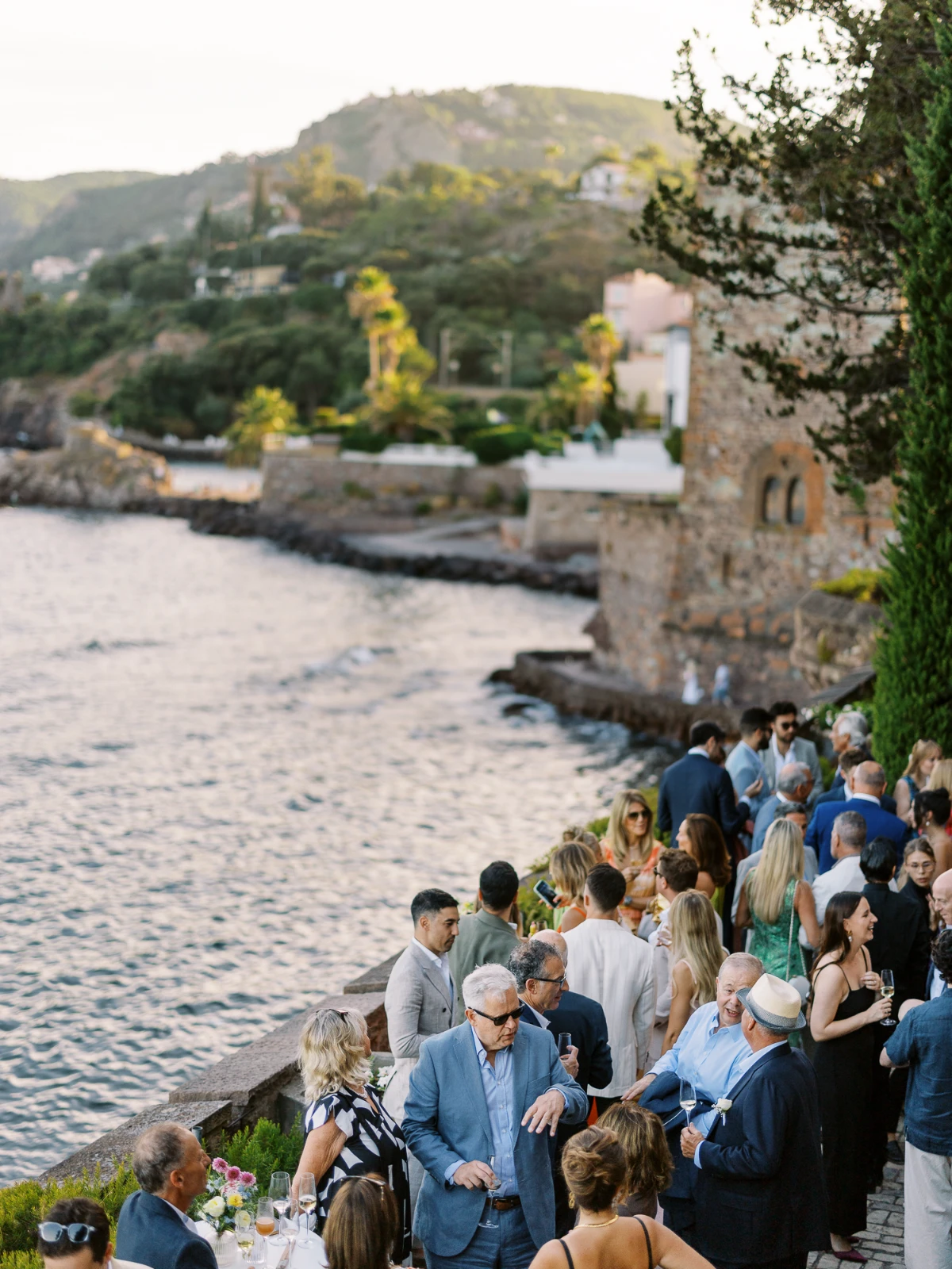 Sophisticated guests enjoy a seaside cocktail reception at sunset, documented by a Cannes wedding photographer.