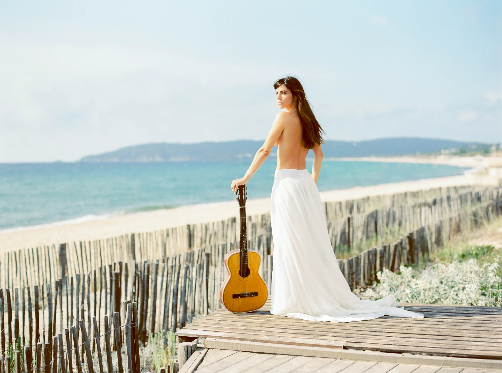 Artistic bridal portrait on a French Riviera boardwalk featuring a vintage guitar.