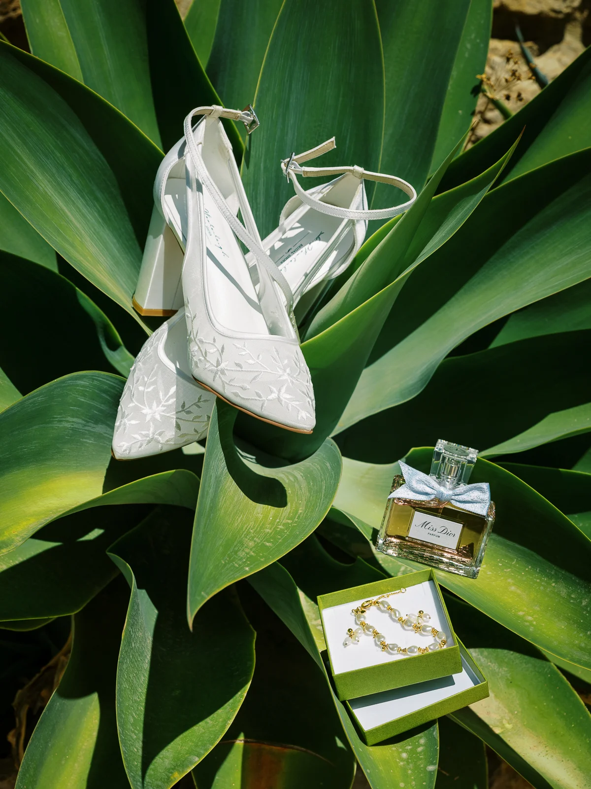 Chaussures de mariée brodées et parfum Miss Dior sur un agave par un photographe mariage France.