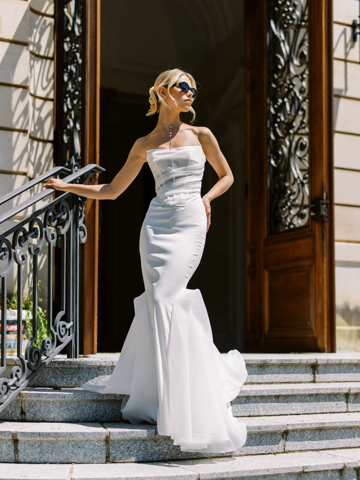 Bride in a mermaid gown on stone steps, wedding photographer price.