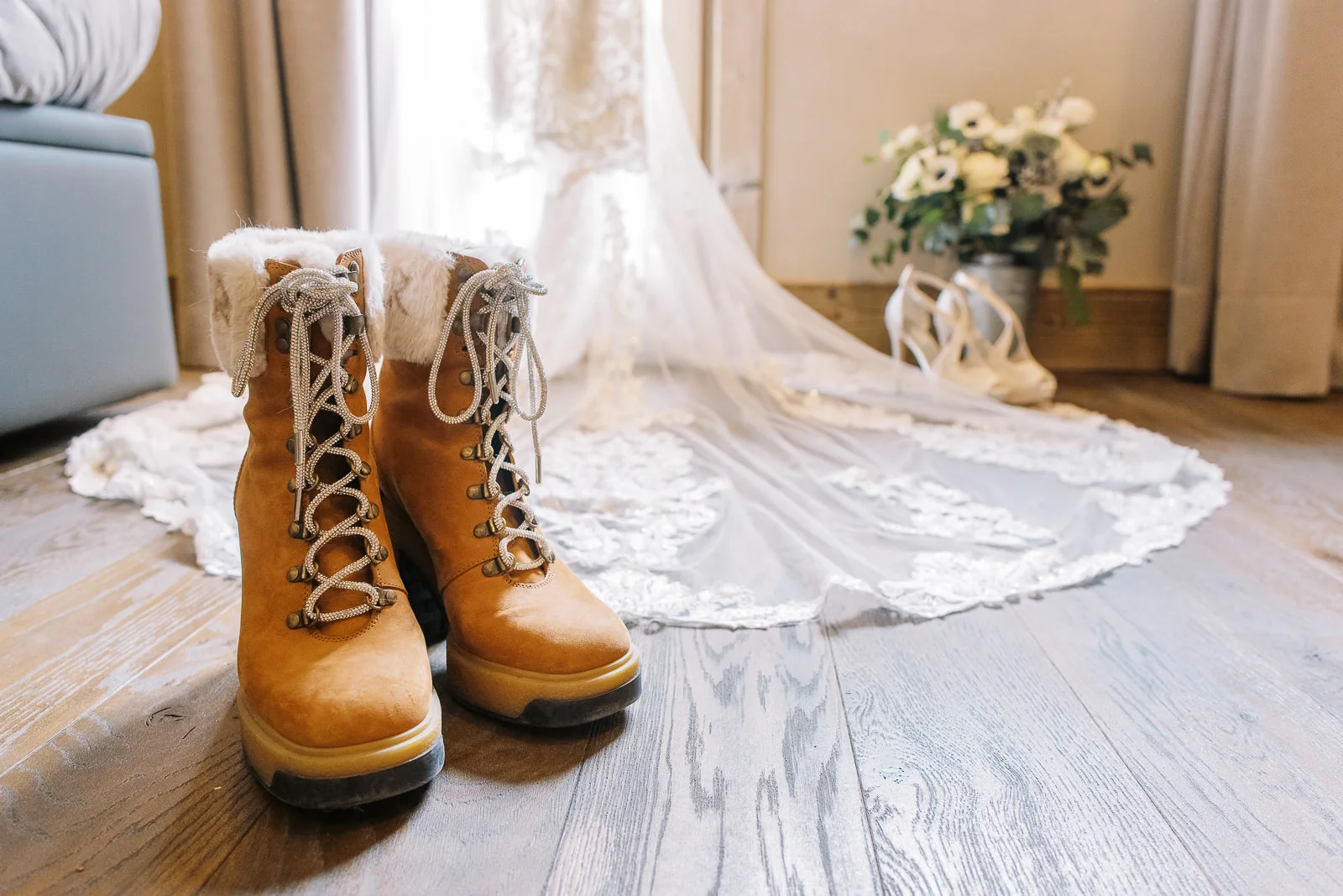 Winter bridal boots on a wooden floor, detailed by a St Moritz wedding photographer before the ceremony.